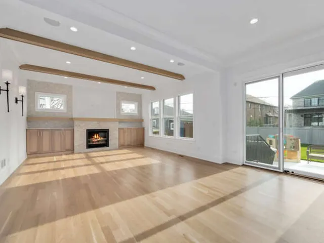 a view of an empty room with a fireplace and a window