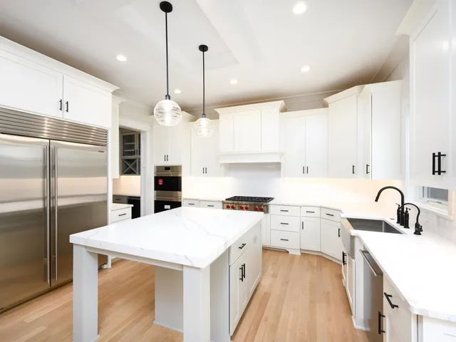 a kitchen with a sink a counter space appliances and cabinets