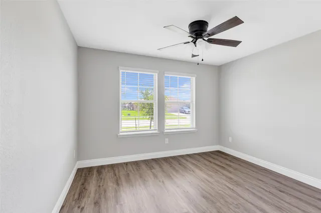 an empty room with wooden floor and a window