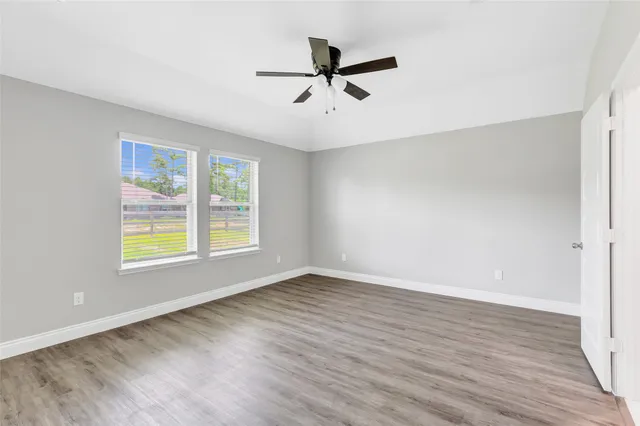 an empty room with wooden floor and window