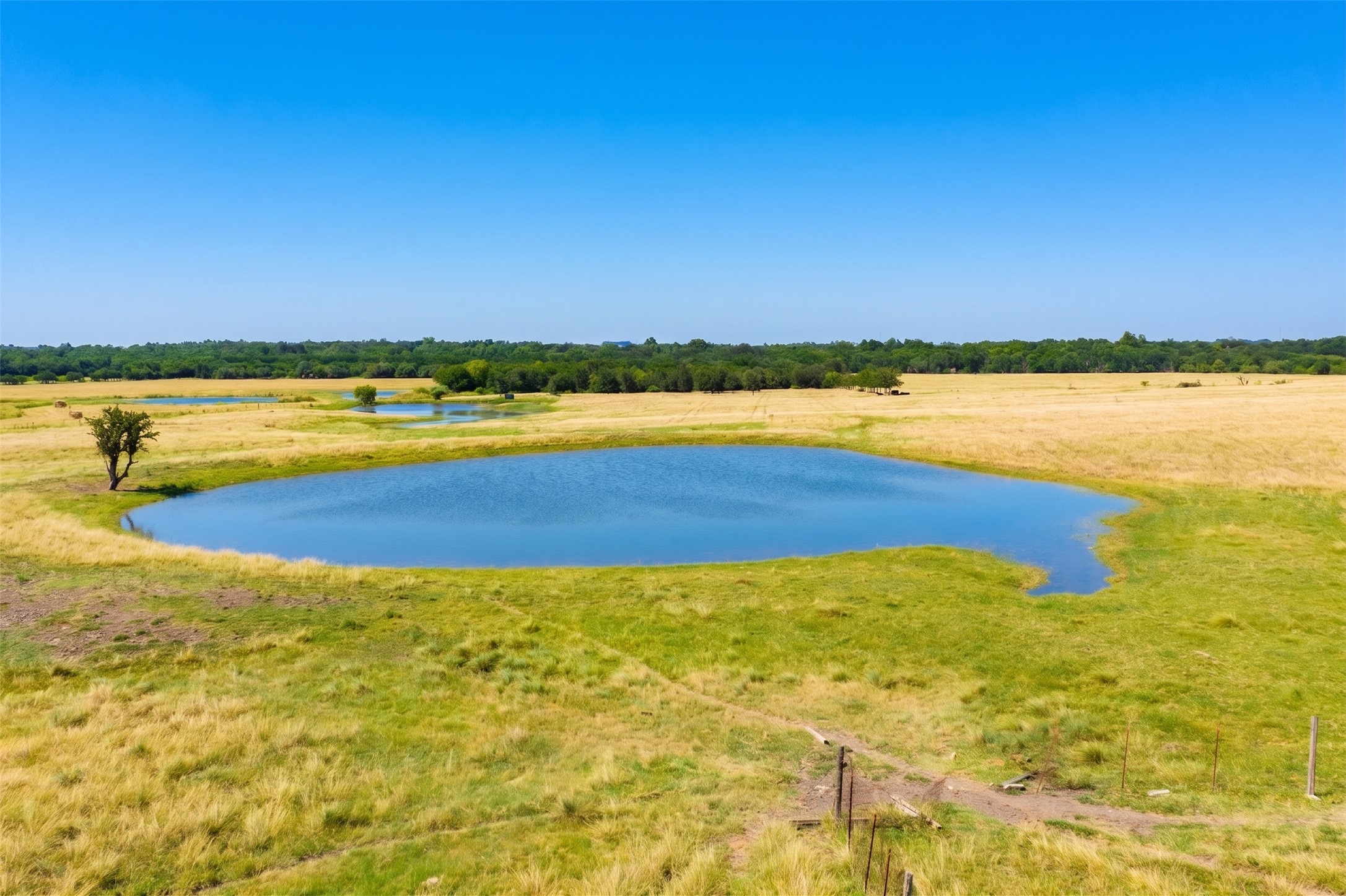 20145 Janak Road Coupland, TX 78615 - Photo 40 of 40 Vast natural landscape showcasing multiple tranquil ponds nestled within golden and green pastures.