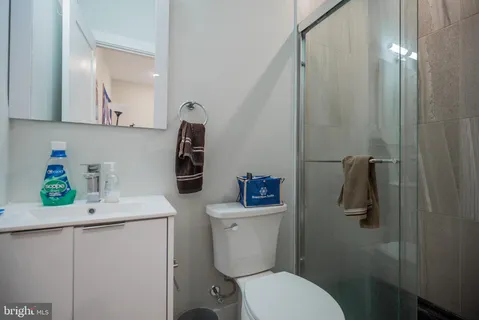 a bathroom with a granite countertop toilet sink and mirror