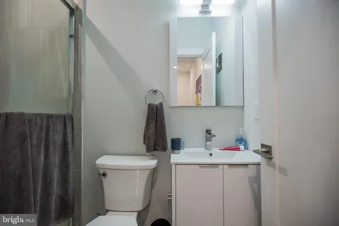 a bathroom with a sink vanity mirror and toilet
