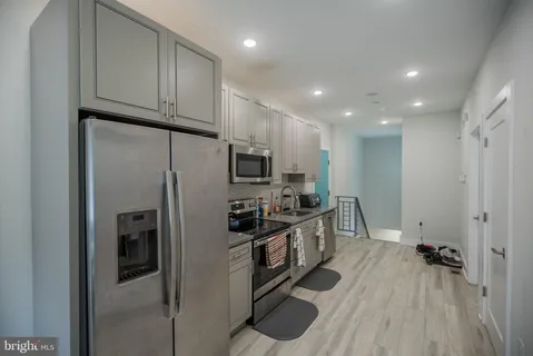 a kitchen with stainless steel appliances kitchen island granite countertop a refrigerator oven a sink and dishwasher