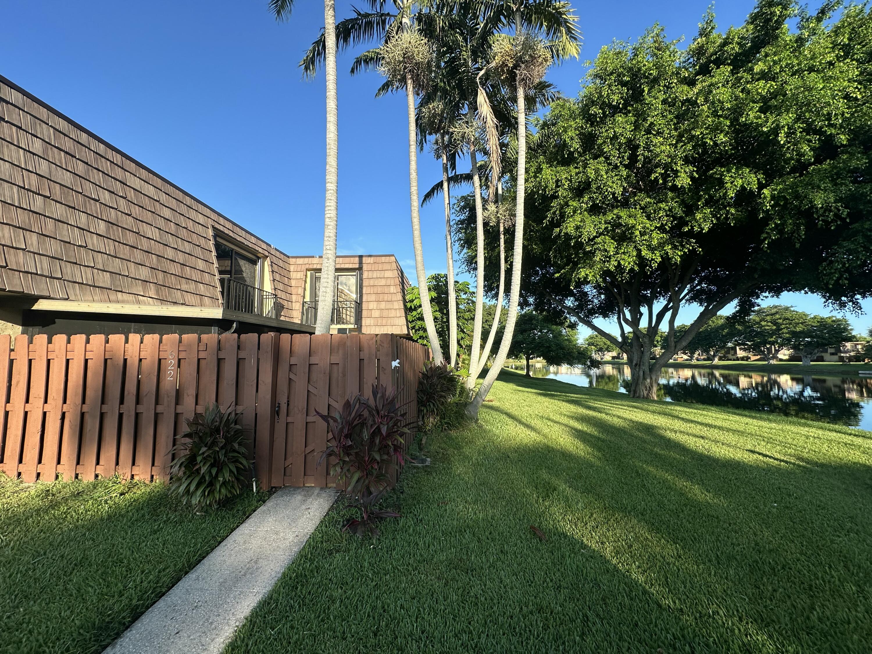 622 Springdale Circle Palm Springs, FL 33461 - Photo 1 of 13 a view of a backyard with plants and a large tree