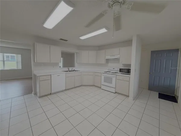 a kitchen with white cabinets a sink and appliances