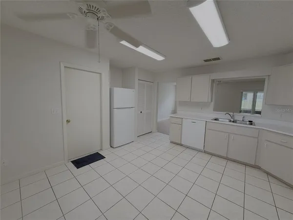 a kitchen with white cabinets a sink dishwasher and a refrigerator