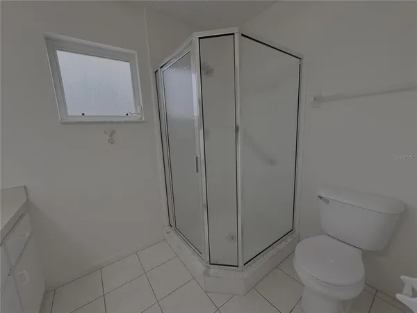 a bathroom with a granite countertop toilet and a shower