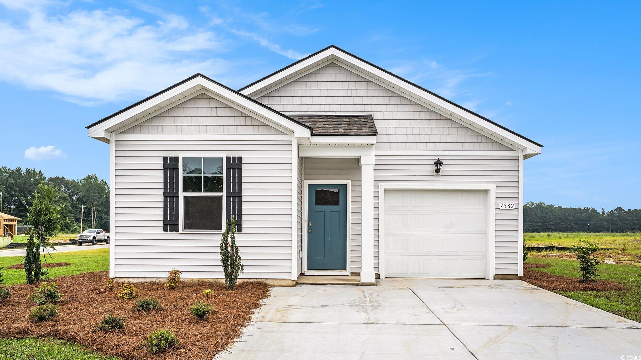 View of front of home with driveway, a garage, and a shingled roof