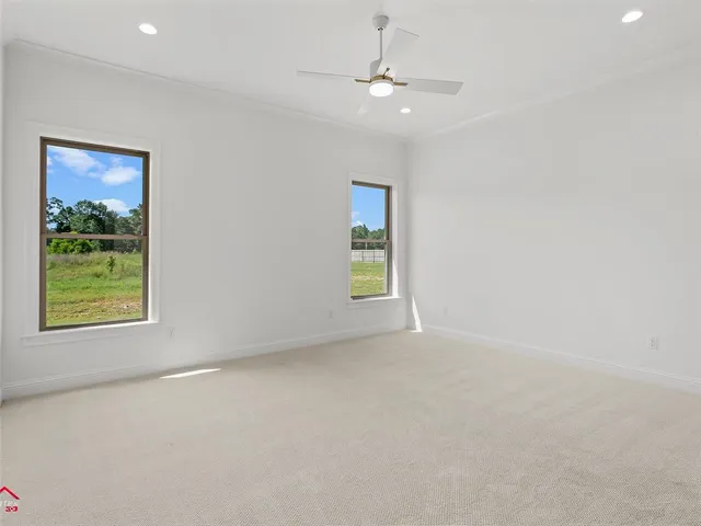 an empty room with windows and fan