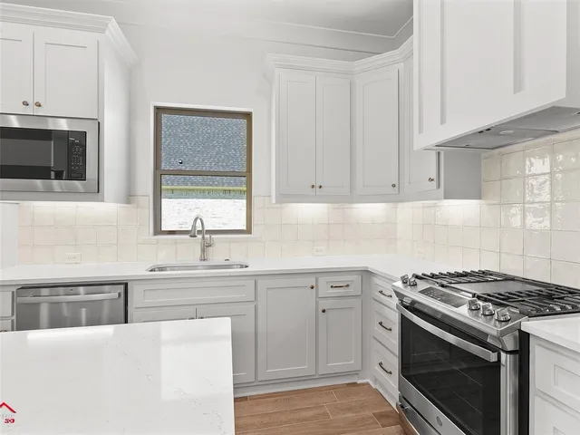 a kitchen with stainless steel appliances granite countertop a sink stove and cabinets