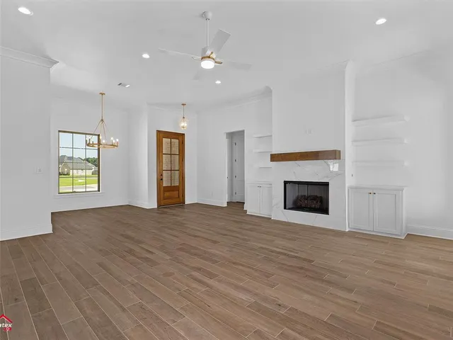a view of an empty room with a window and fireplace