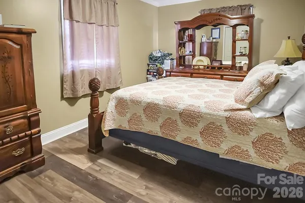 a bedroom with a bed and a flat tv screen on the dresser