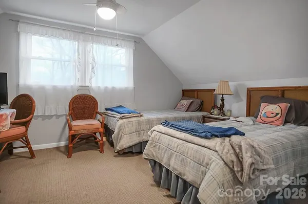 a bedroom with two beds and a chair