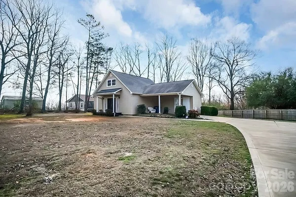 a front view of a house with a yard covered with trees