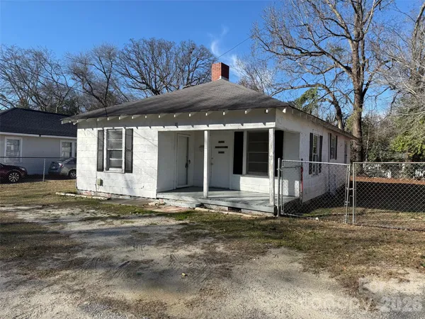 a view of a house with a yard and large tree