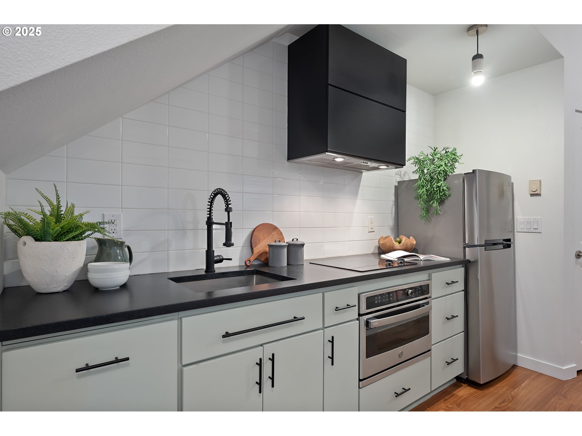 4303 Southeast Division Street Portland, OR 97206 - Photo 10 of 40 a kitchen with a sink a potted plant and cabinets