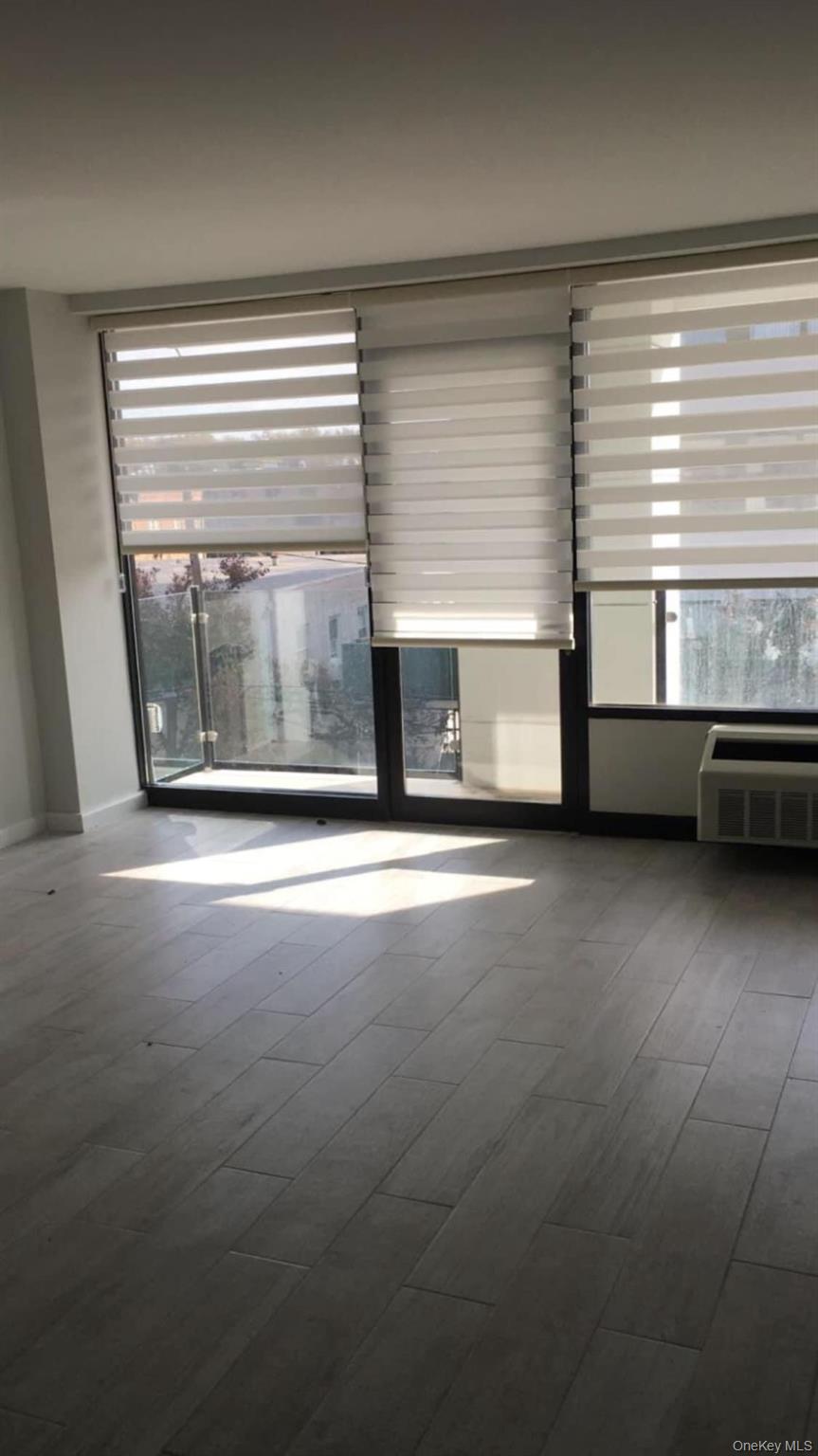 5 Grace Avenue, Unit 2J Great Neck, NY 11021 - Photo 15 of 15 a living room with a large window