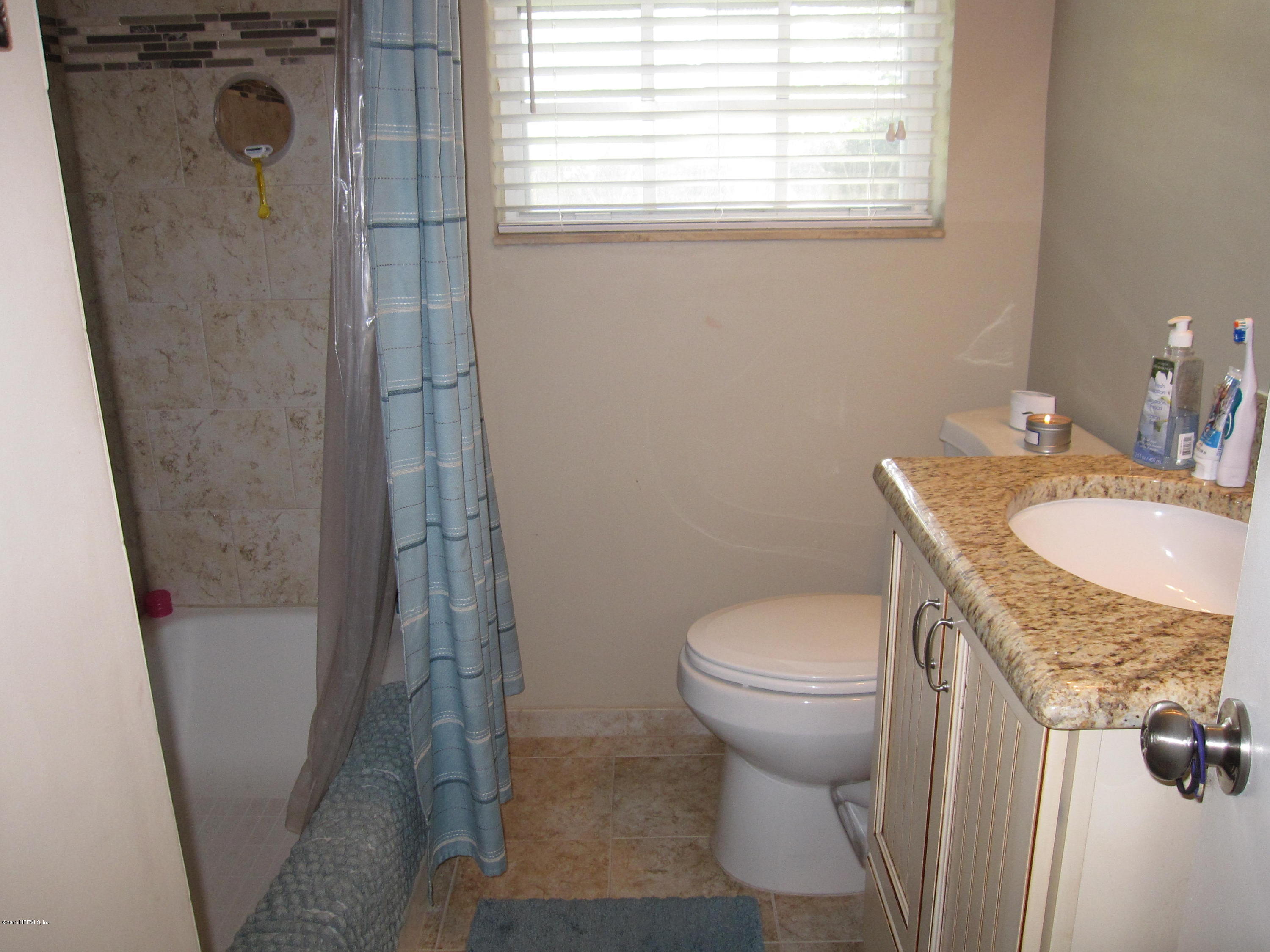 6416 Wesleyan Road Jacksonville, FL 32217 - Photo 15 of 35 a bathroom with a granite countertop sink toilet and shower