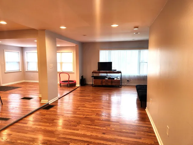 a view of a kitchen with kitchen island granite countertop a stove top oven a sink with granite countertops and living room view