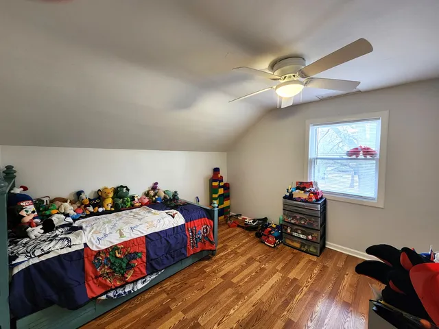 a bed room with a bed and a wooden floor