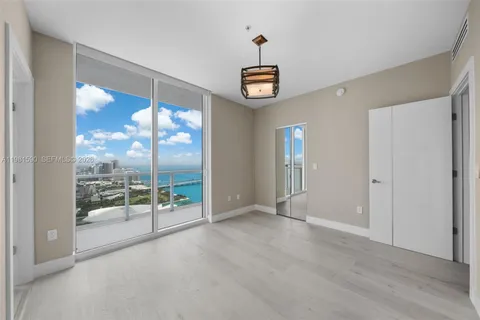 a view of an empty room with window wooden floor