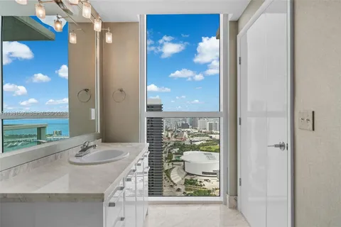 a bathroom with a granite countertop sink a mirror and a shower
