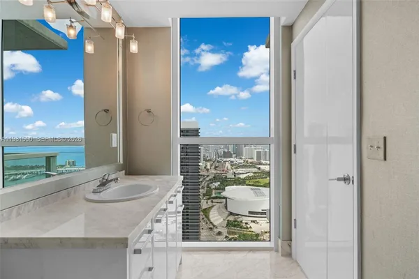 a bathroom with a granite countertop sink a mirror and a shower