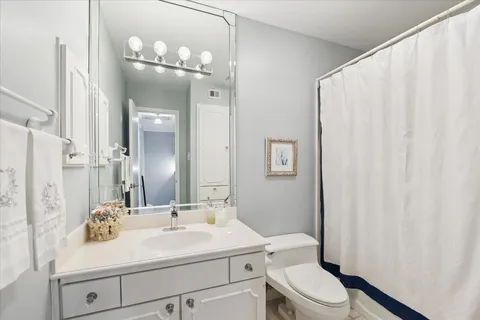 a bathroom with a sink vanity mirror and toilet