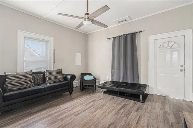a living room with furniture and a wooden floor
