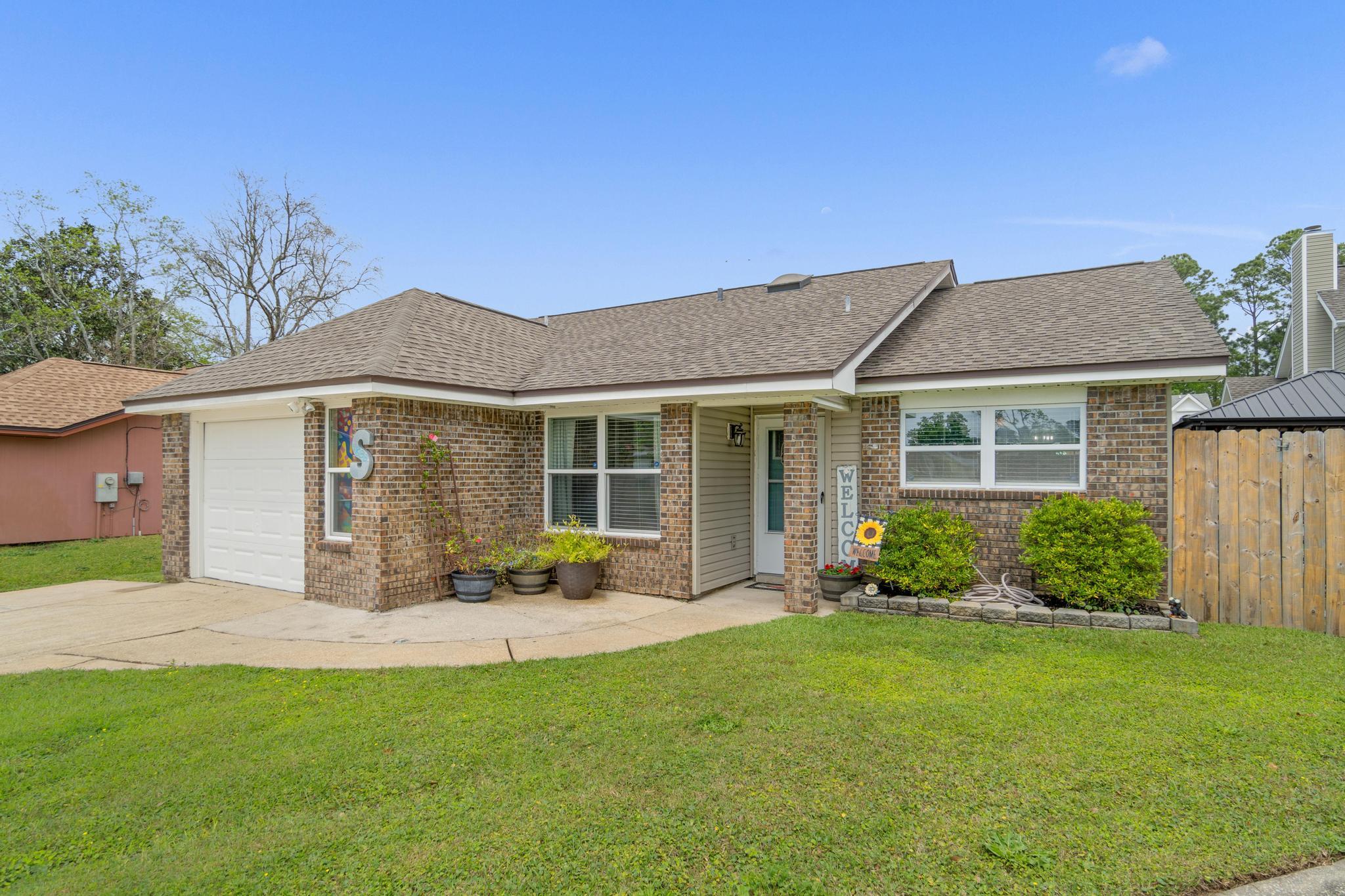 1833 Hunters Path Fort Walton Beach, FL 32547 - Photo 1 of 34 a front view of a house with a garden and yard