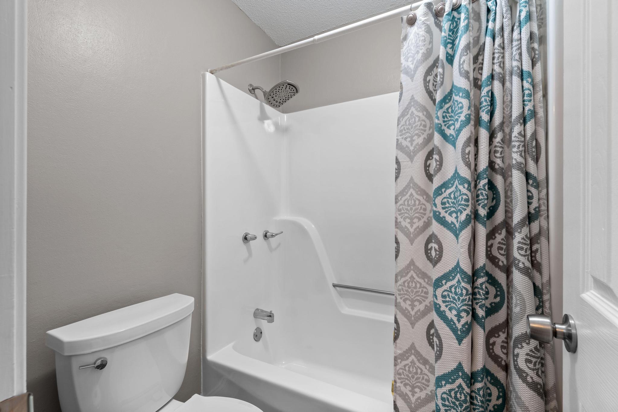 1833 Hunters Path Fort Walton Beach, FL 32547 - Photo 18 of 34 a bathroom with a toilet and shower curtain