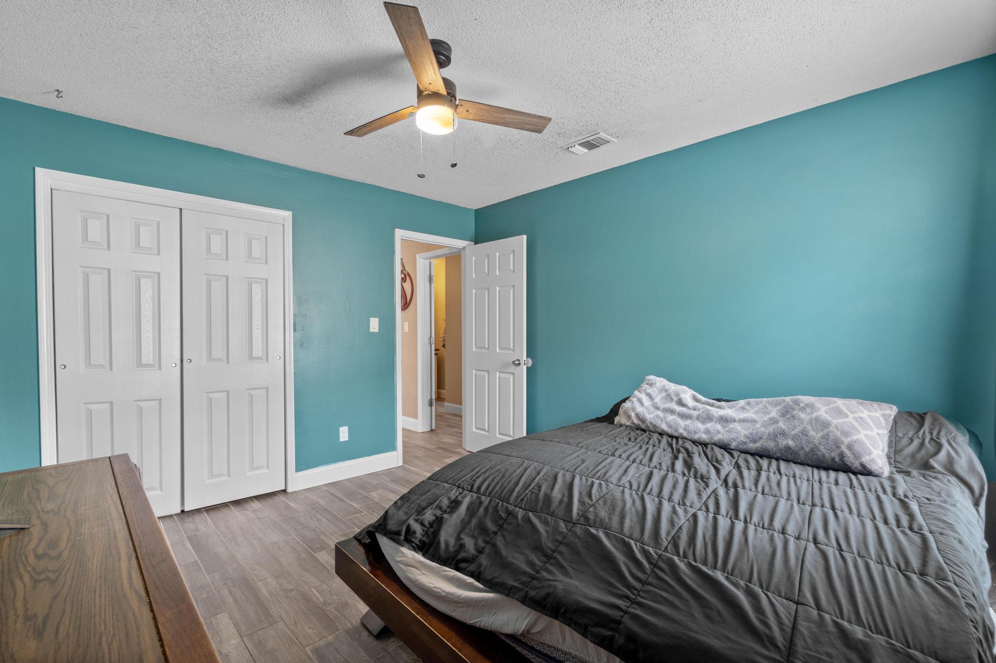 1833 Hunters Path Fort Walton Beach, FL 32547 - Photo 20 of 34 a bedroom with a bed and a chandelier