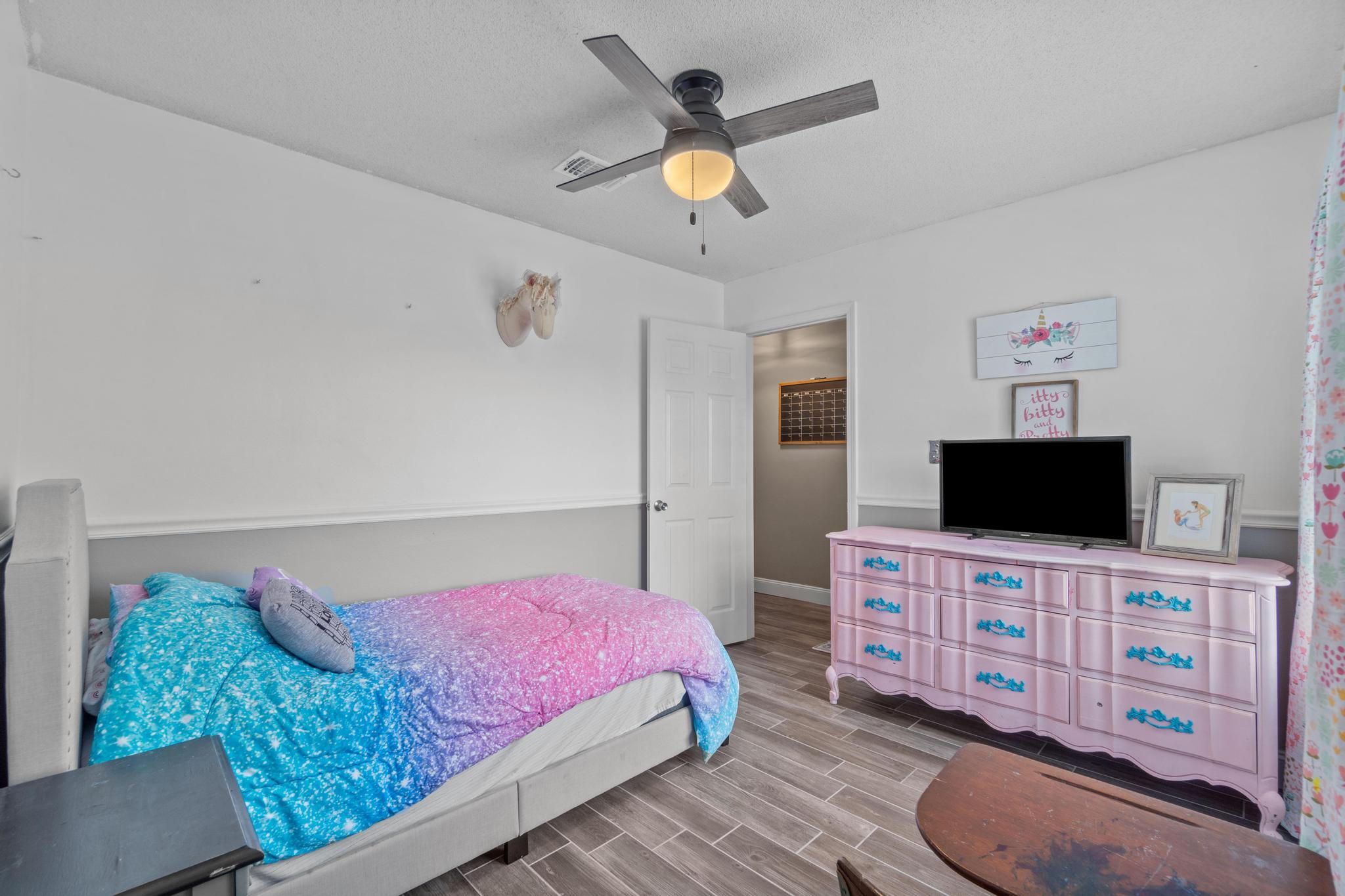 1833 Hunters Path Fort Walton Beach, FL 32547 - Photo 22 of 34 a bedroom with a bed and a flat screen tv