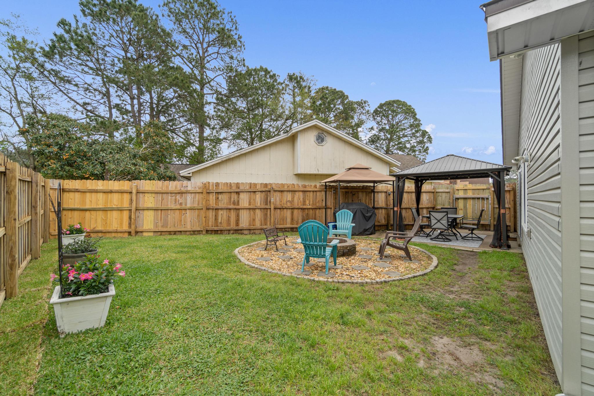 1833 Hunters Path Fort Walton Beach, FL 32547 - Photo 30 of 34 a backyard of a house with wooden table and chairs