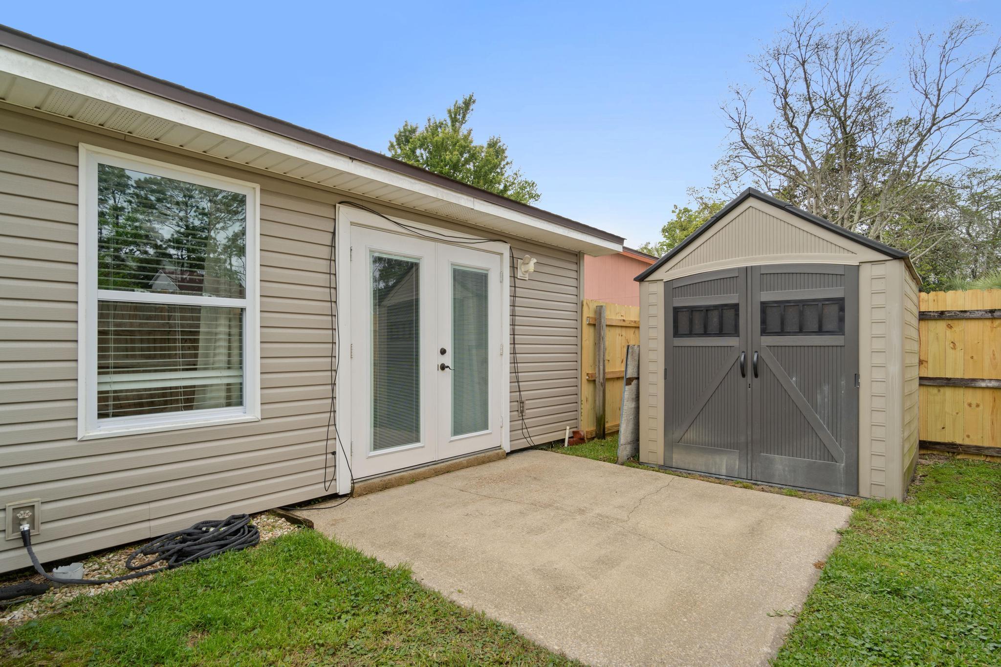 1833 Hunters Path Fort Walton Beach, FL 32547 - Photo 32 of 34 a front view of a house with a garden and yard