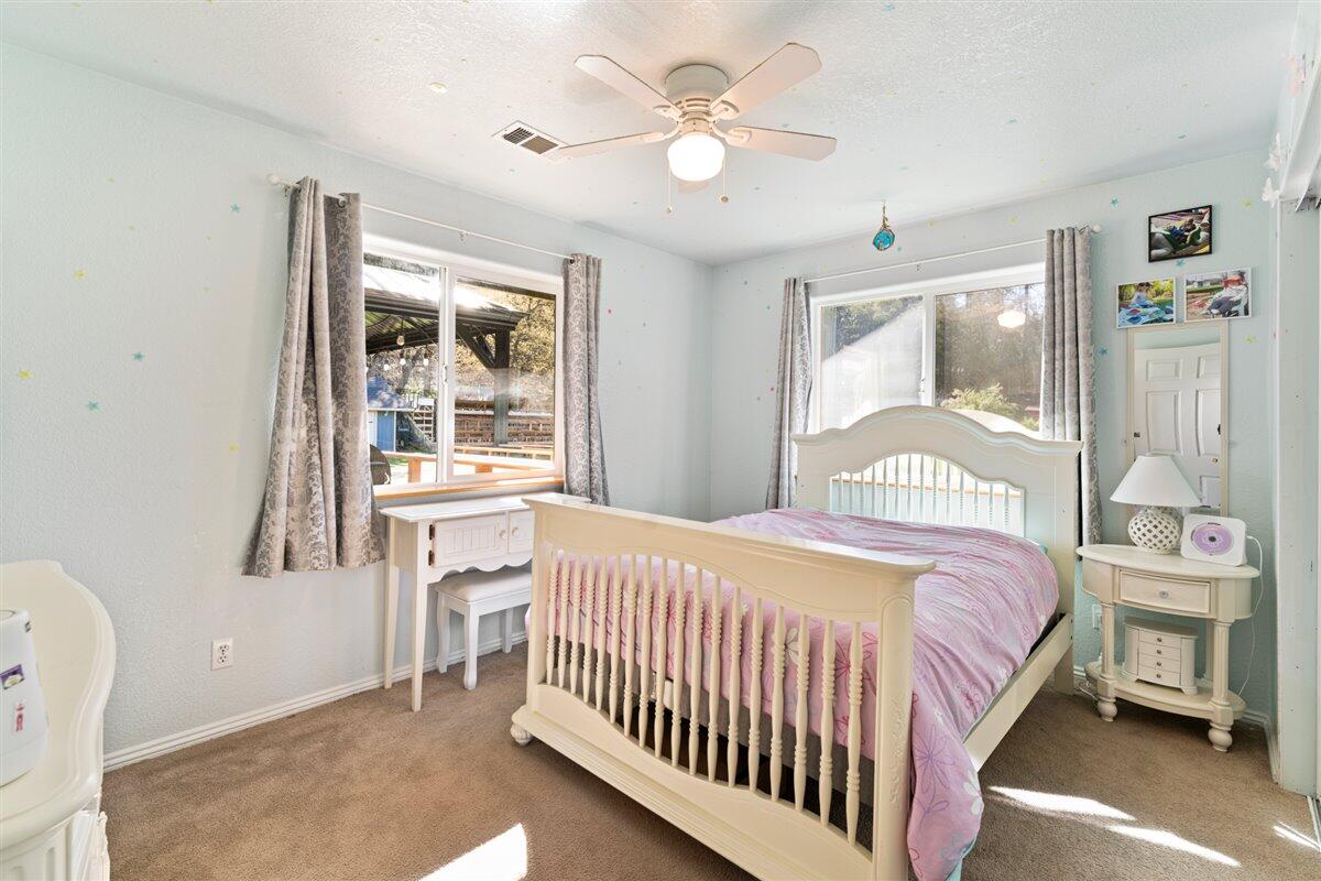 649 Pleasant Valley Road Merlin, OR 97532 - Photo 26 of 57 a bedroom with a bed next to a window with a chandelier