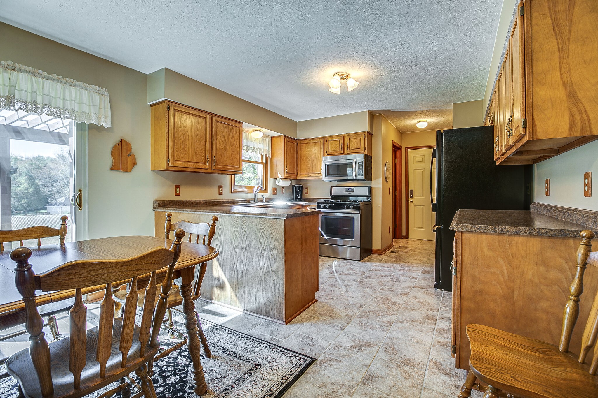 9513 Link Road Christiana, TN 37037 - Photo 9 of 34 a kitchen with stainless steel appliances granite countertop a stove a refrigerator a kitchen island and chairs in it