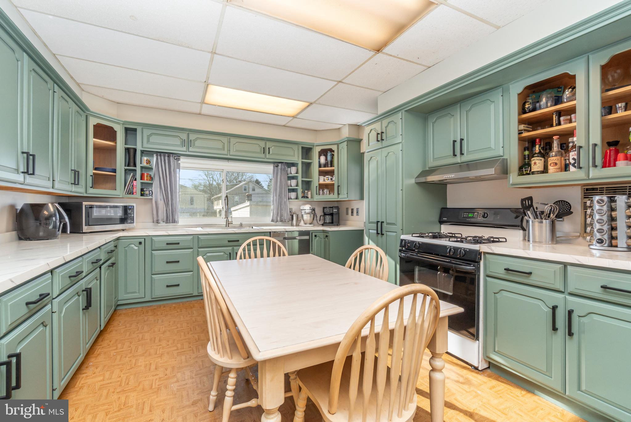 2246 Reading Avenue Reading, PA 19609 - Photo 12 of 27 a kitchen with a stove a sink a dining table and chairs