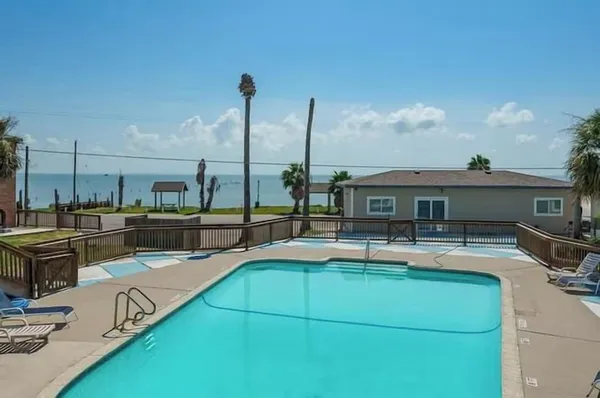 a view of a house with pool and chairs