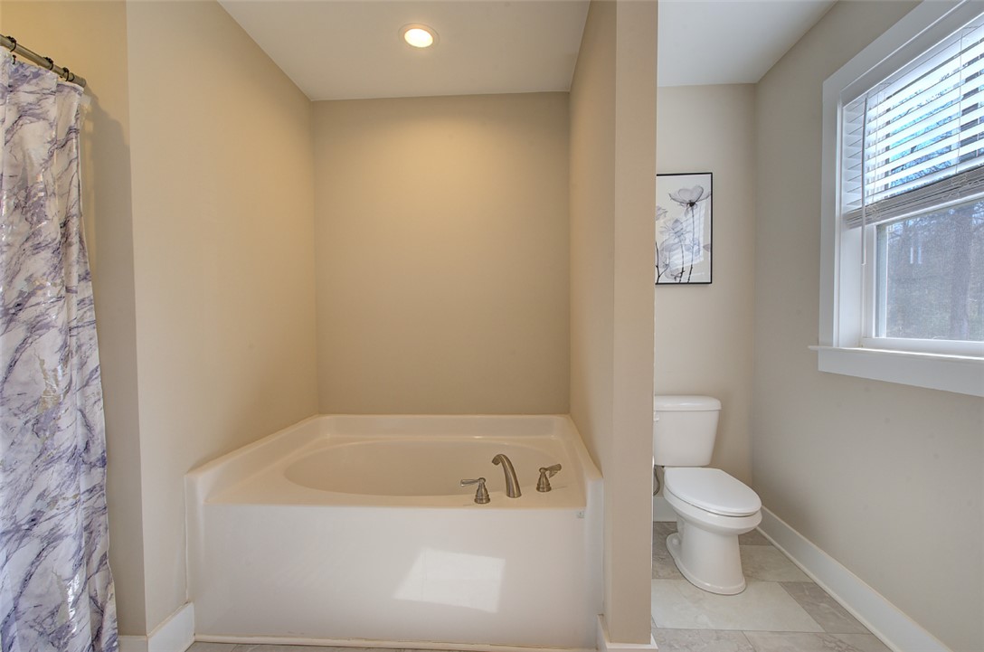 110 Sanders Drive Easley, SC 29642 - Photo 13 of 23 This functional bathroom features a clean tub, toilet, and a window for natural light.