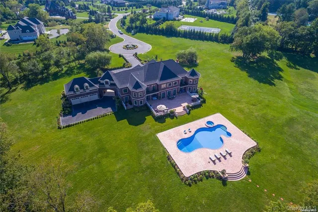 an aerial view of a house with a garden and swimming pool