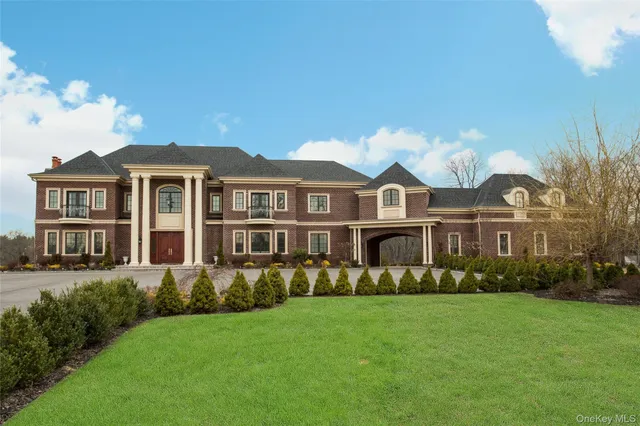 a front view of a house with a garden and trees