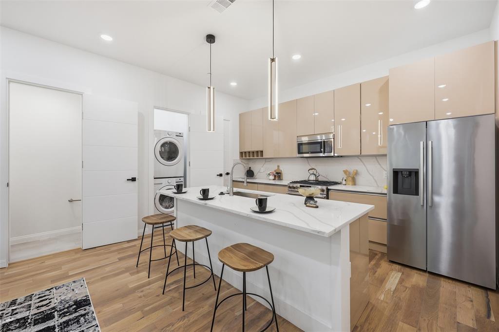 1920 Caddo Street, Unit 204 Dallas, TX 75204 - Photo 11 of 33 a kitchen with stainless steel appliances kitchen island a table chairs and a refrigerator