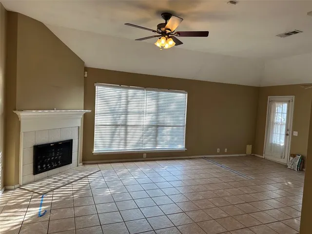 a view of an empty room with a fireplace and a window