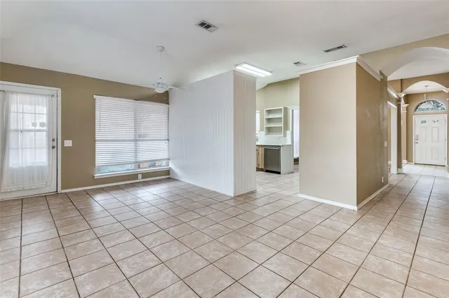 a view of an empty room with window and fire place