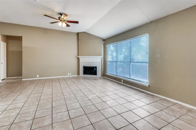 an empty room with windows and fireplace