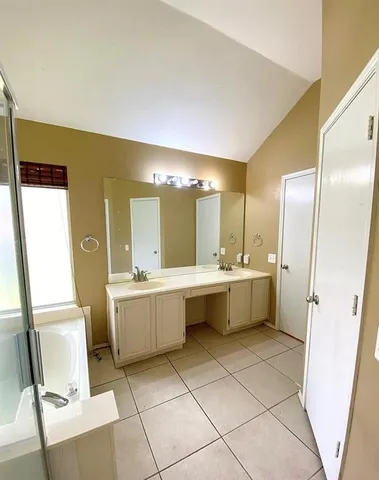 a large bathroom with a double vanity sink mirror and bathtub