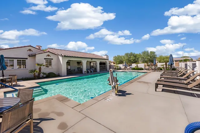 a kitchen with granite countertop a stove a sink a dining table and chairs