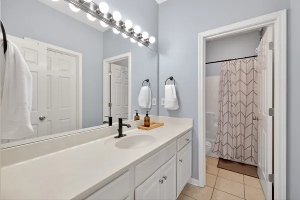 a bathroom with a shower curtain and a toilet next to a window